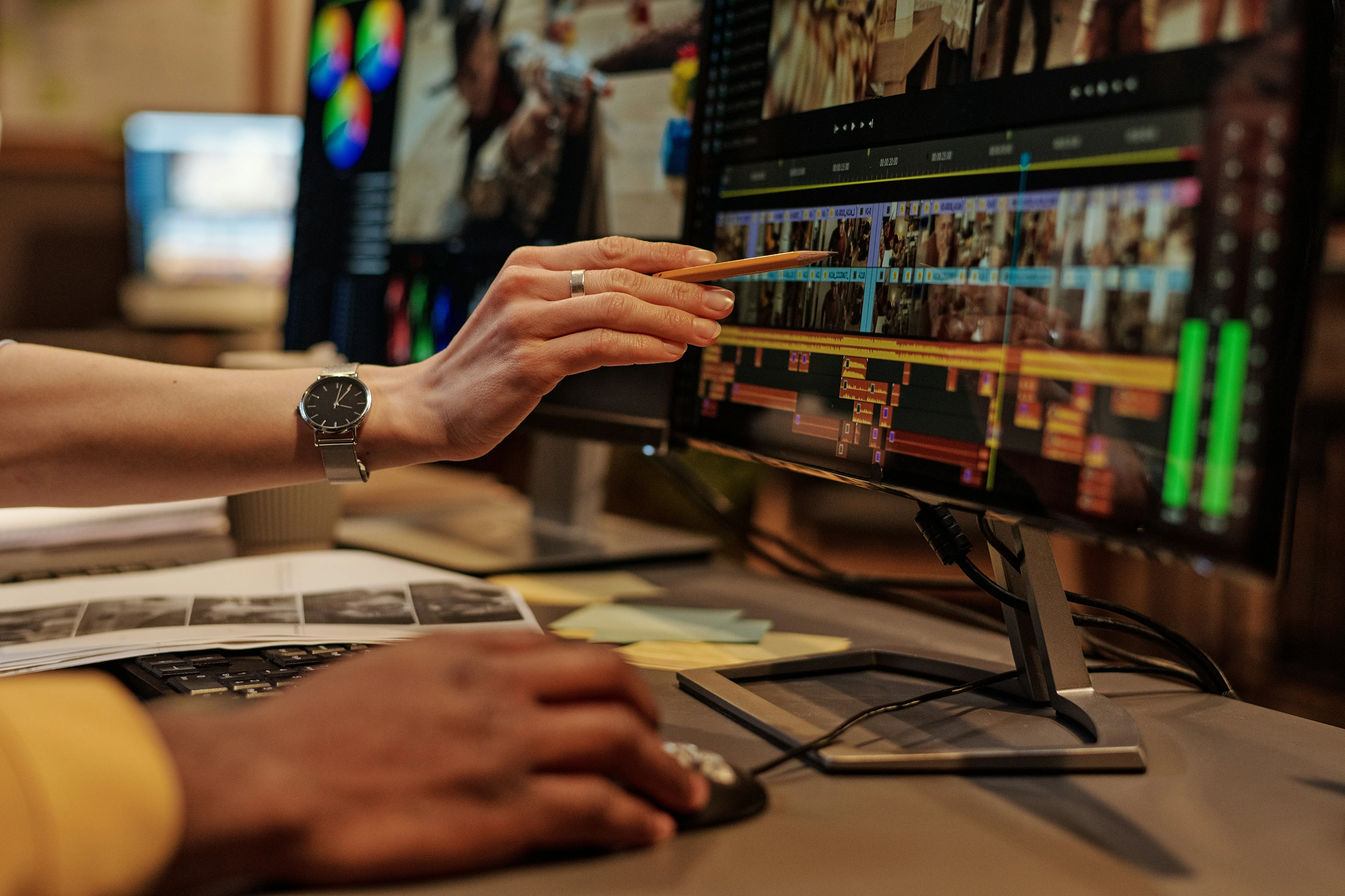 hand of two people on a desk at a video editing station.