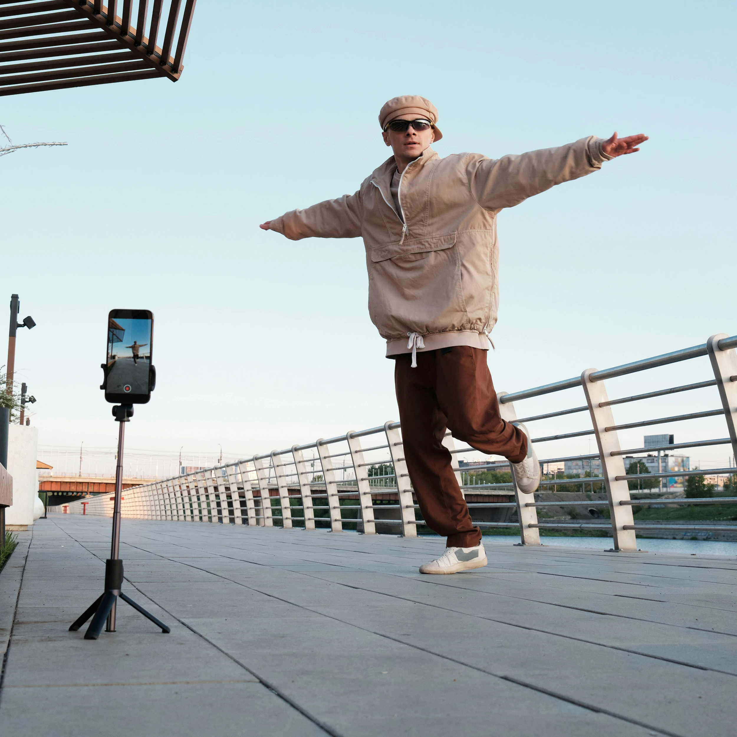 An image of a young man dancing while being recorded with a mobile phone.